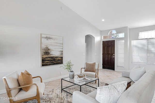 living room featuring light tile patterned floors and high vaulted ceiling