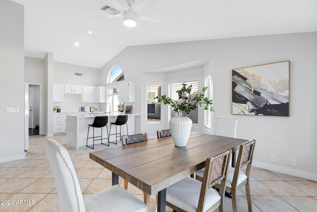 tiled dining area with ceiling fan and vaulted ceiling