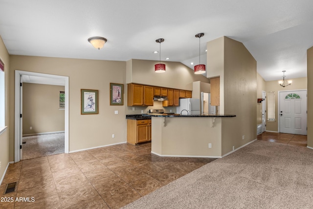69 E Mohawk Dr, Flagstaff, AZ 86005 - kitchen featuring dark countertops, baseboards, a breakfast bar area, a peninsula, and pendant lighting