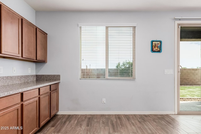 20261 W Desert Bloom St, Buckeye, AZ 85326 - unfurnished dining area with baseboards and wood finished floors