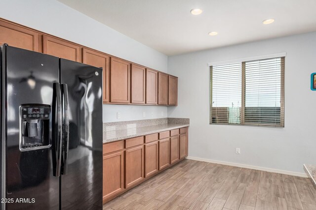 20261 W Desert Bloom St, Buckeye, AZ 85326 - kitchen with black refrigerator with ice dispenser, light wood-style floors, baseboards, recessed lighting, and brown cabinets