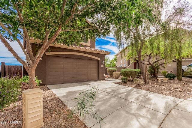 20261 W Desert Bloom St, Buckeye, AZ 85326 - view of front of house featuring a garage, fence, stucco siding, driveway, and a tile roof