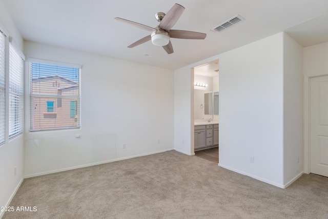 14870 W Encanto Blvd Unit 2006, Goodyear, AZ 85395 - unfurnished bedroom with light colored carpet, connected bathroom, and a ceiling fan