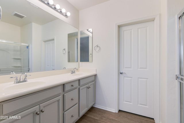 14870 W Encanto Blvd Unit 2006, Goodyear, AZ 85395 - full bathroom featuring double vanity, wood finished floors, and a shower with shower door