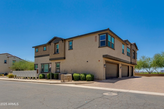 14870 W Encanto Blvd Unit 2006, Goodyear, AZ 85395 - view of front of home featuring an attached garage, stucco siding, and driveway