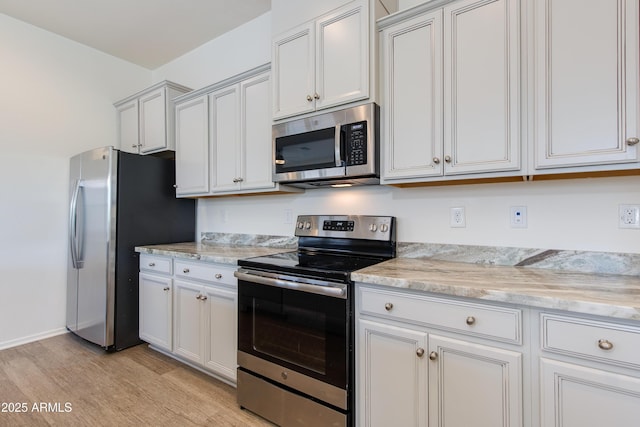 14870 W Encanto Blvd Unit 2006, Goodyear, AZ 85395 - kitchen with stainless steel appliances, light wood-style floors, light stone counters, and white cabinets