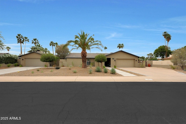 single story home featuring an attached garage, stucco siding, concrete driveway, and fence
