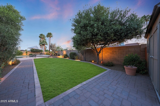 yard at dusk featuring a patio