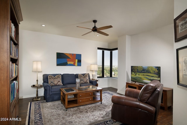 living room with ceiling fan and dark wood-type flooring