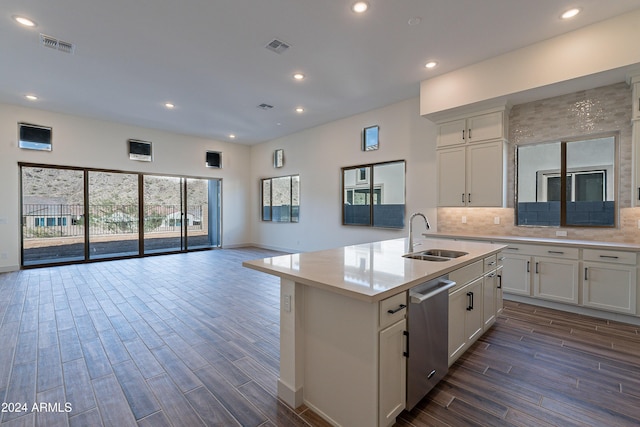 kitchen with dishwasher, light countertops, open floor plan, and a sink