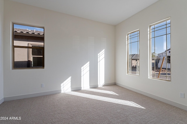 carpeted empty room featuring baseboards