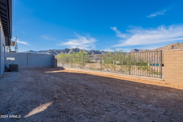 view of yard featuring a mountain view, cooling unit, and fence