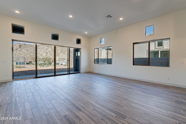 empty room with visible vents, recessed lighting, baseboards, and wood finished floors