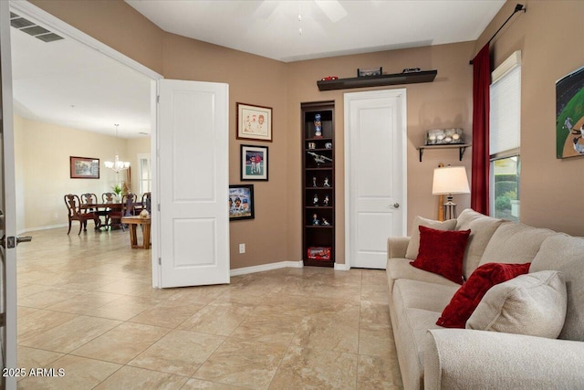 living room featuring ceiling fan with notable chandelier