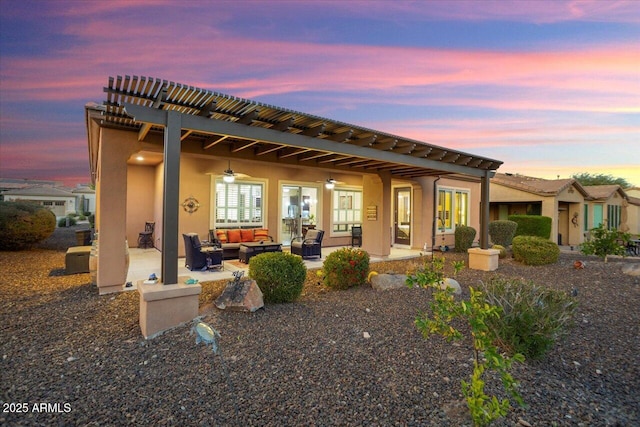 back house at dusk with an outdoor hangout area, a patio, and ceiling fan