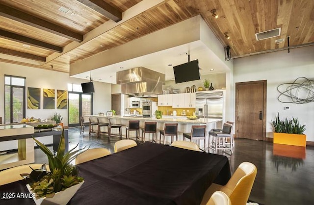 dining room featuring beamed ceiling, a high ceiling, and wood ceiling