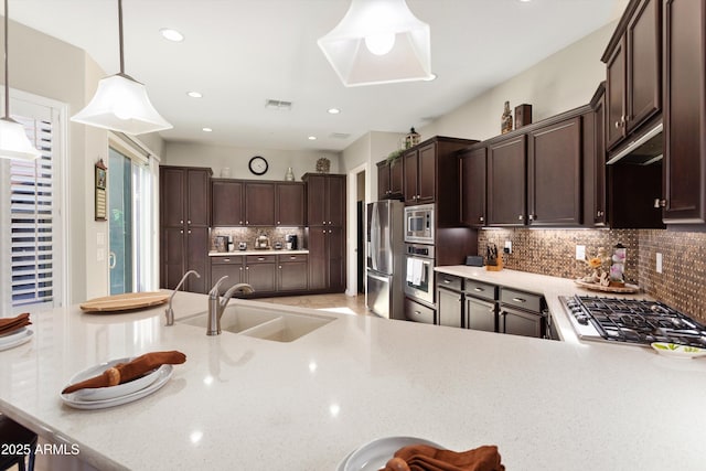 12935 W Lone Tree Trl, Peoria, AZ 85383 - kitchen with dark brown cabinetry, stainless steel appliances, backsplash, and a sink