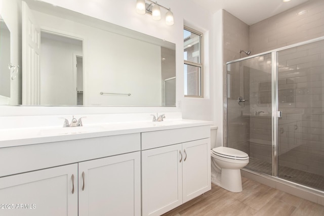 bathroom featuring toilet, an enclosed shower, vanity, and hardwood / wood-style floors