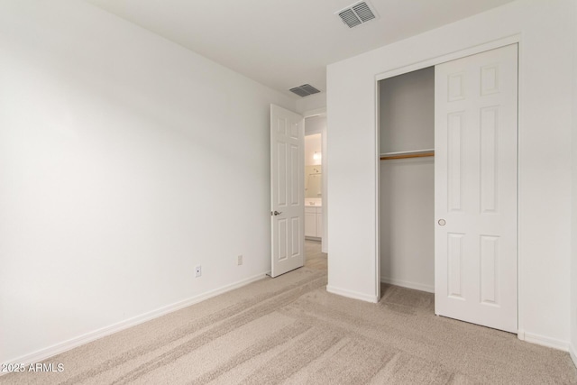 unfurnished bedroom with a closet and light carpet