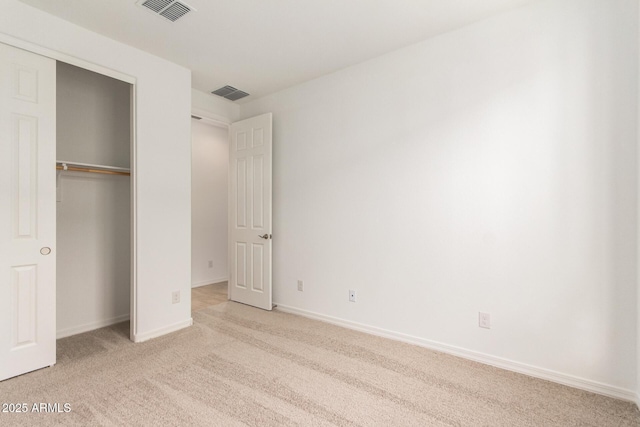 unfurnished bedroom featuring a closet and light carpet