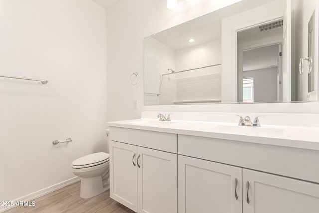 bathroom with walk in shower, vanity, hardwood / wood-style flooring, and toilet