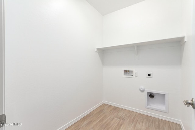 clothes washing area featuring electric dryer hookup, hookup for a washing machine, light hardwood / wood-style flooring, and gas dryer hookup