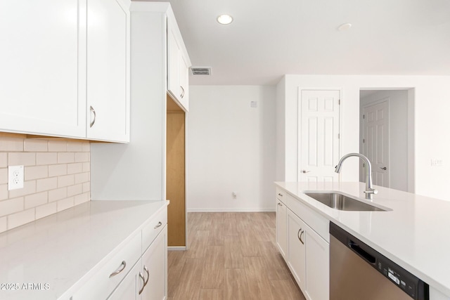 kitchen with white cabinetry, dishwasher, and sink