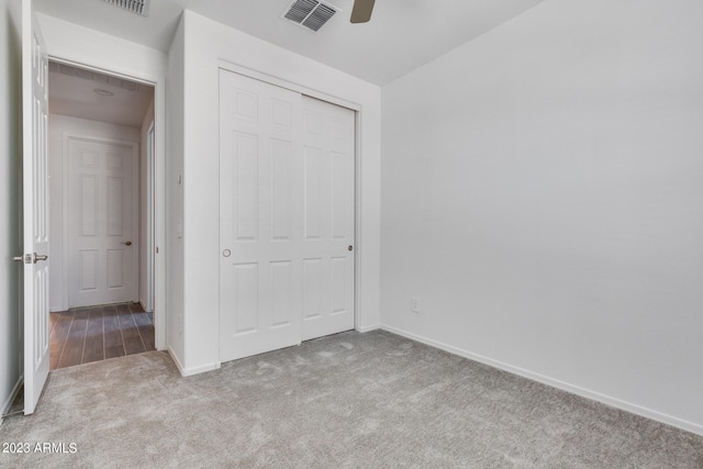 unfurnished bedroom with ceiling fan, carpet flooring, and a closet