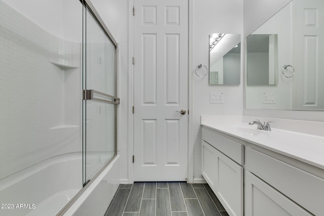 bathroom with vanity and combined bath / shower with glass door