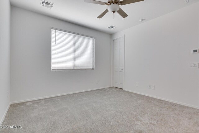 carpeted spare room featuring ceiling fan