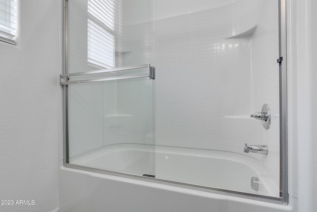 bathroom with shower / bath combination with glass door