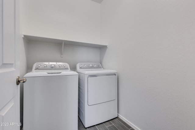 clothes washing area with dark wood-type flooring and washing machine and dryer