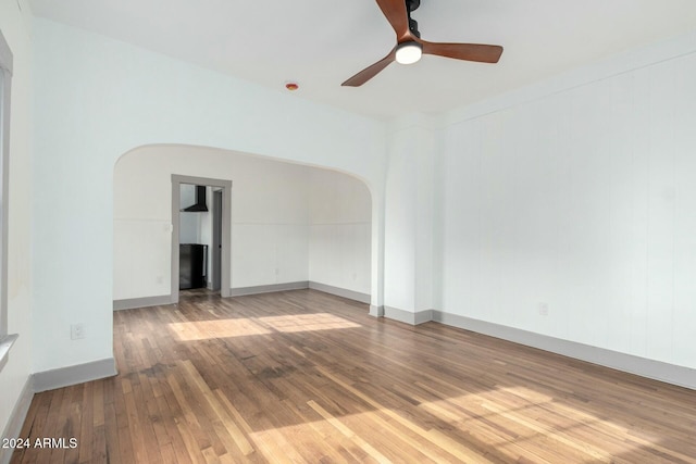 empty room with hardwood / wood-style floors and ceiling fan