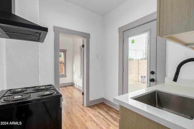 kitchen with sink, black range with electric cooktop, light hardwood / wood-style flooring, range hood, and light brown cabinetry