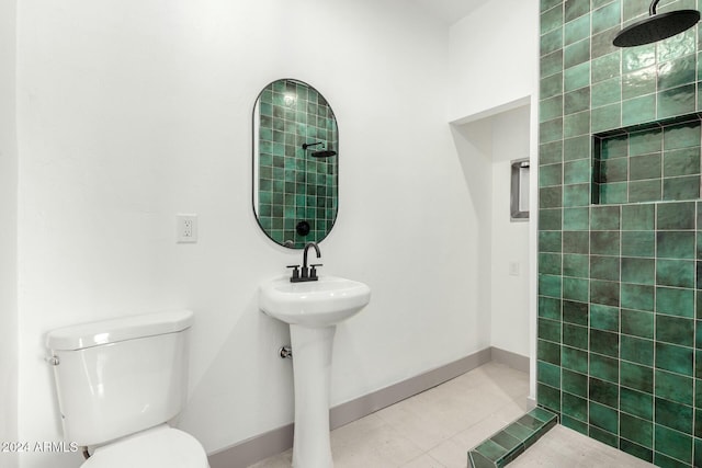 bathroom featuring tile patterned floors, toilet, and a tile shower