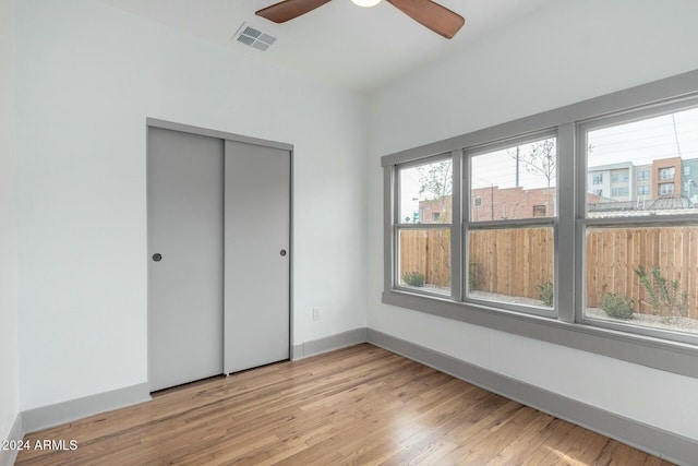 unfurnished bedroom with ceiling fan, a closet, and light hardwood / wood-style floors