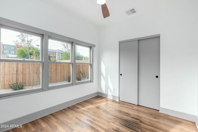 unfurnished bedroom featuring a closet, hardwood / wood-style flooring, and ceiling fan