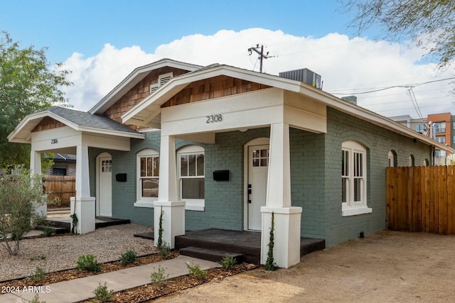 bungalow featuring covered porch and central AC unit