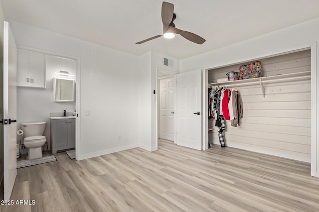 bedroom with sink, ensuite bath, light wood-type flooring, a closet, and ceiling fan