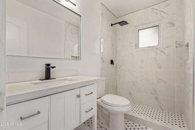 bathroom featuring vanity, toilet, and a tile shower