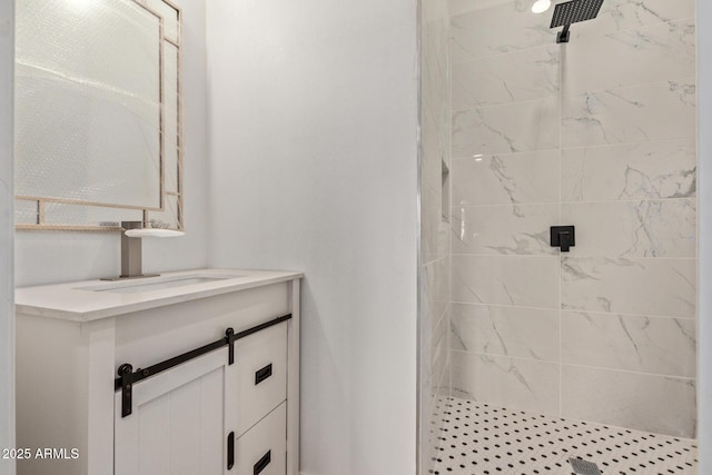 bathroom featuring tiled shower and vanity