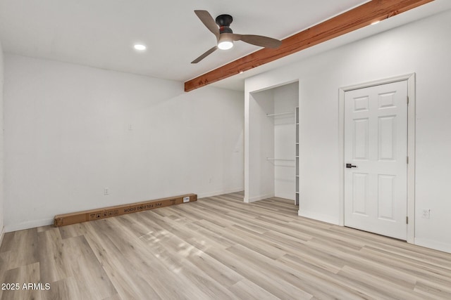 unfurnished bedroom with beamed ceiling, ceiling fan, light wood-type flooring, and a closet