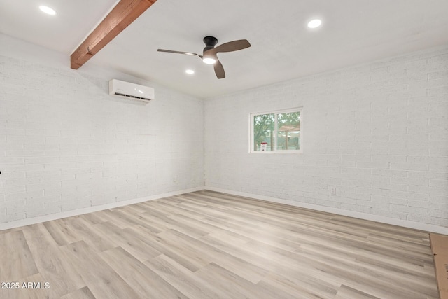 unfurnished room featuring a wall mounted air conditioner, light wood-type flooring, ceiling fan, brick wall, and beam ceiling