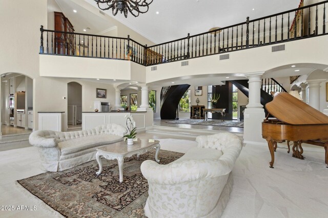 6467 E Sierra Vista Dr, Paradise Valley, AZ 85253 - living area featuring a high ceiling, decorative columns, stairs, and visible vents