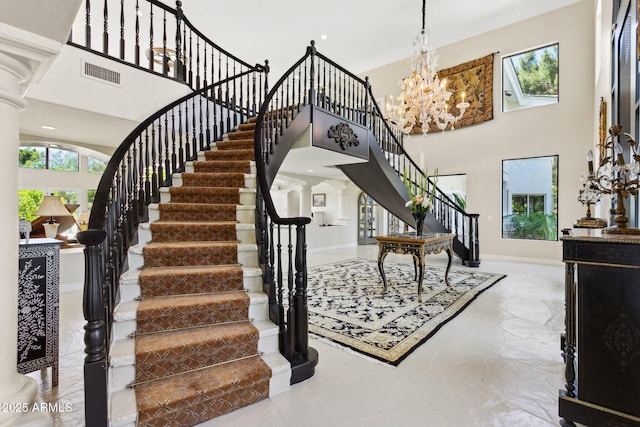 6467 E Sierra Vista Dr, Paradise Valley, AZ 85253 - stairway with visible vents, baseboards, a high ceiling, ornate columns, and a notable chandelier