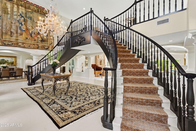 6467 E Sierra Vista Dr, Paradise Valley, AZ 85253 - staircase featuring visible vents, arched walkways, a notable chandelier, a high ceiling, and ornate columns