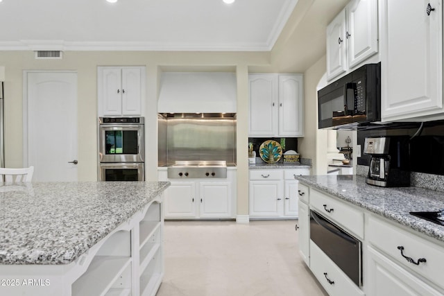 6467 E Sierra Vista Dr, Paradise Valley, AZ 85253 - kitchen with crown molding, white cabinets, light stone countertops, black appliances, and a warming drawer