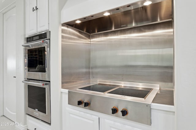 6467 E Sierra Vista Dr, Paradise Valley, AZ 85253 - kitchen with double oven, white cabinetry, and black electric cooktop