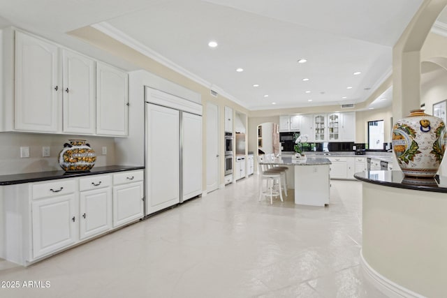 6467 E Sierra Vista Dr, Paradise Valley, AZ 85253 - kitchen with stainless steel double oven, arched walkways, built in refrigerator, ornamental molding, and a breakfast bar