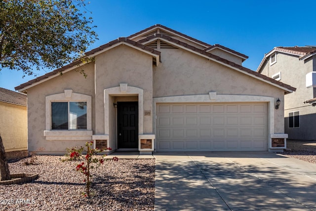 view of front facade with driveway, an attached garage, and stucco siding